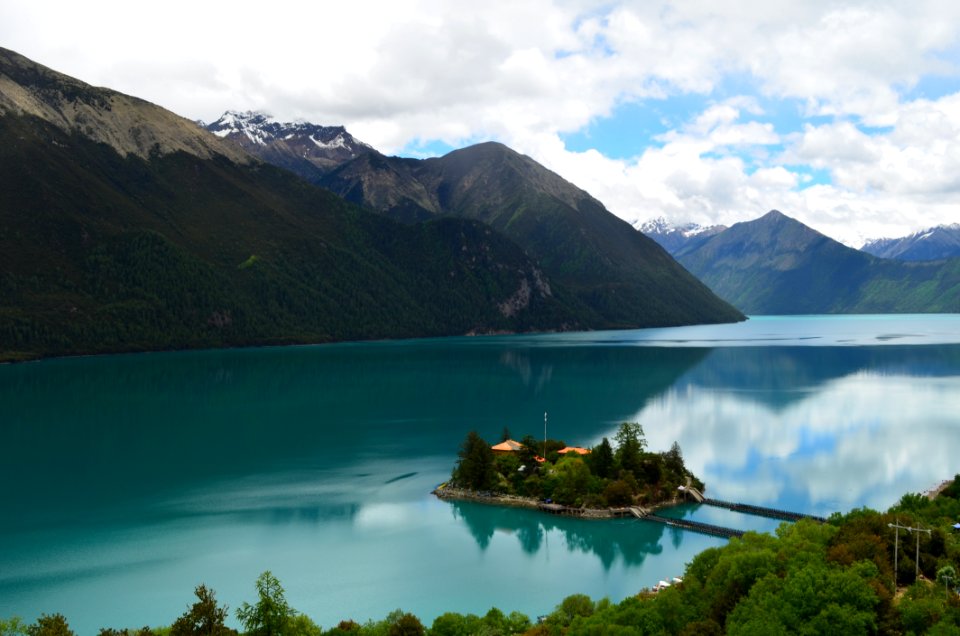 Green Small Island Sorrounded By Bodies Of Water Under Cloudy Sky