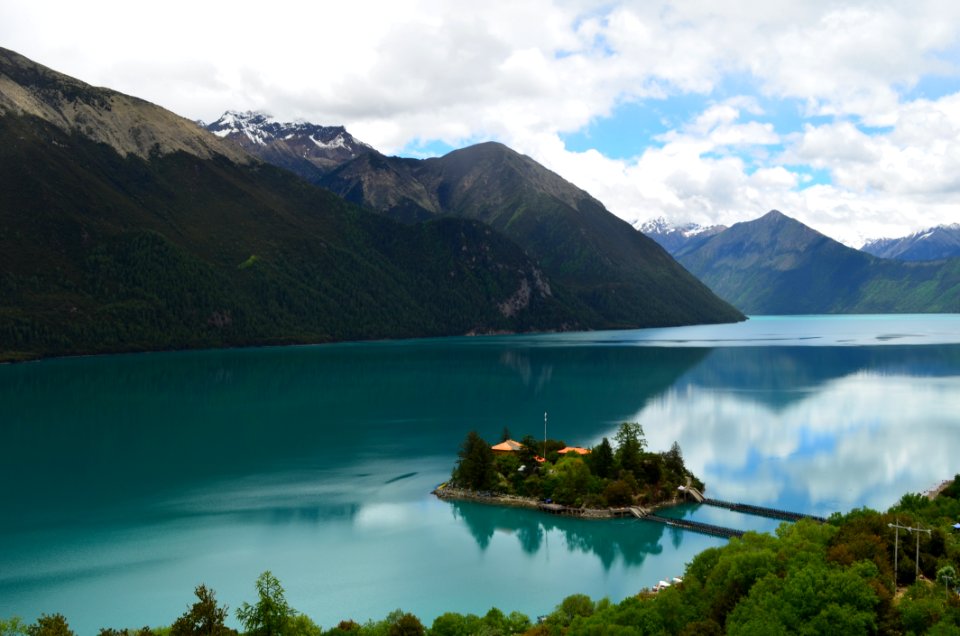 Green Small Island Sorrounded By Bodies Of Water Under Cloudy Sky photo