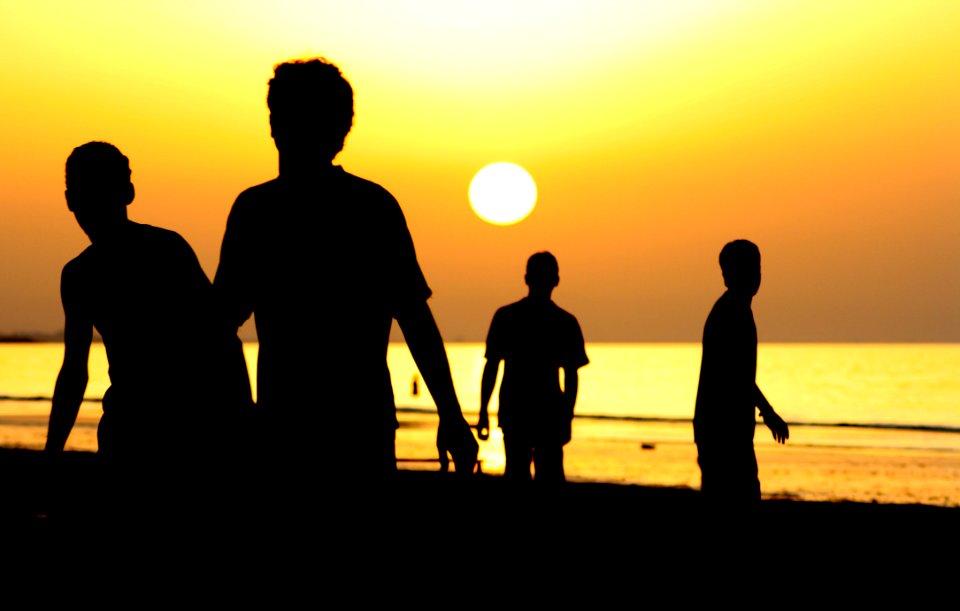 Silhouette Of 4 People Near Ocean During Sunset