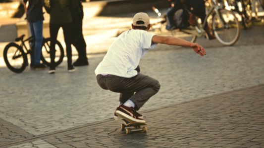 Man In White Shirt And Brown Jeans Riding Skateboard photo