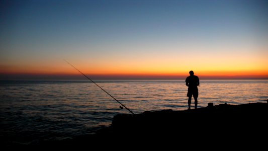 Person Fishing During Sunset