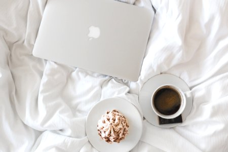 Laptop Computer And Coffee On Bed photo