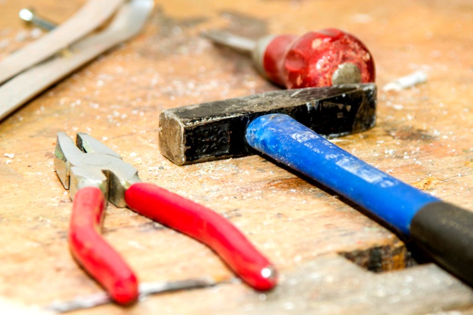 Red And Gray Pliers Beside Blue And Black Hammer