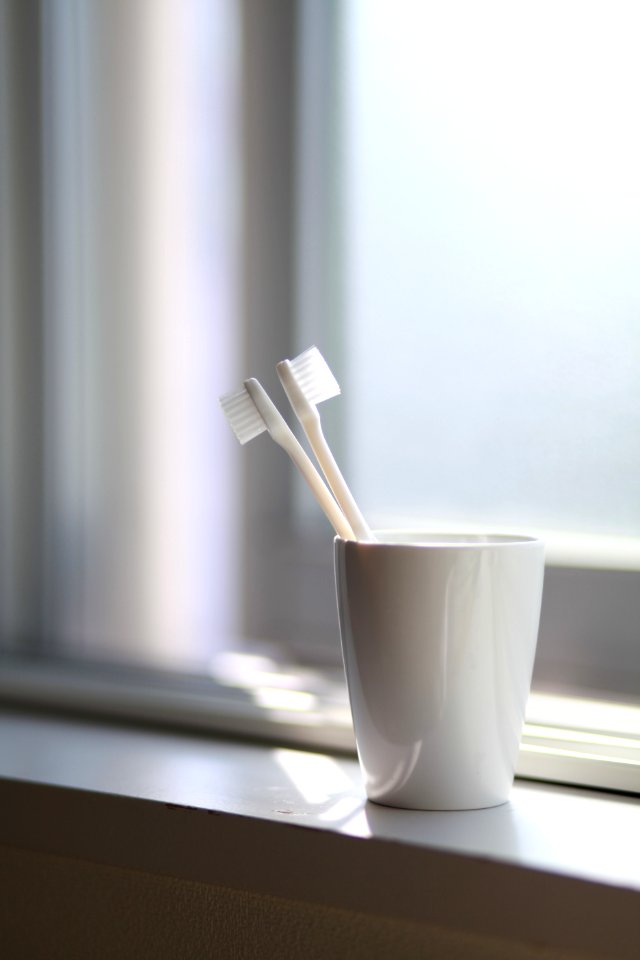Two White Toothbrush Inside The White Ceramic Cup