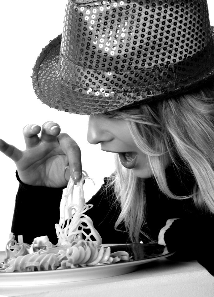 Woman In Sweater And Sequin Fedora Hat Holding Noodles In Grayscale Photography