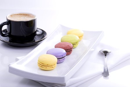 Black Teacup And 5 French Macaroons On Plate photo