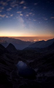 Crater Between Mountains Under Blue Sky White Clouds And Stars During Sunset photo