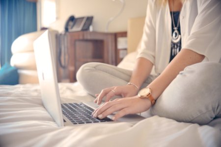 Woman Sitting On Bed With Computer photo