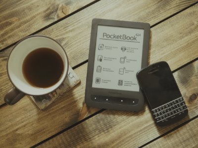 Blackberry Qwerty Phone Near Gray Pocket Book Case Beside Black Rim White Ceramic Teacup photo