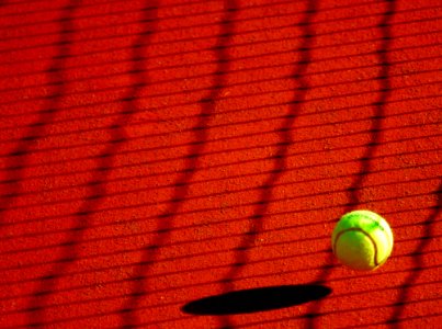 Green Tennis Ball On Red Floor During Sunny Day photo
