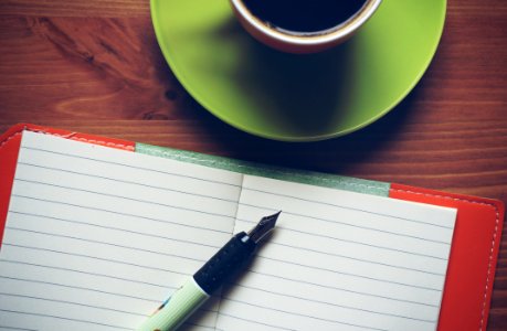 Fountain Pen On Top Of Notebook Beside Drinking Mug