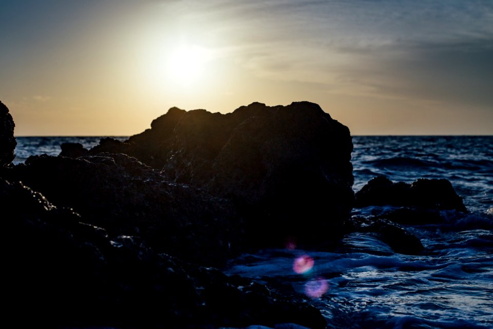 Black Stones On Sea Side During Sunset photo