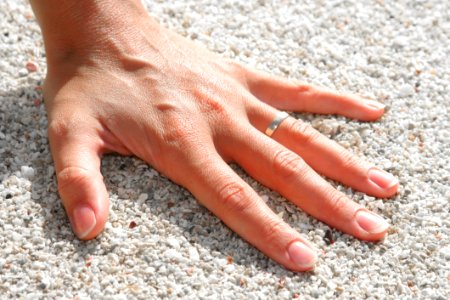 Lef Humand Hand Wearing Silver Ring On The Soil