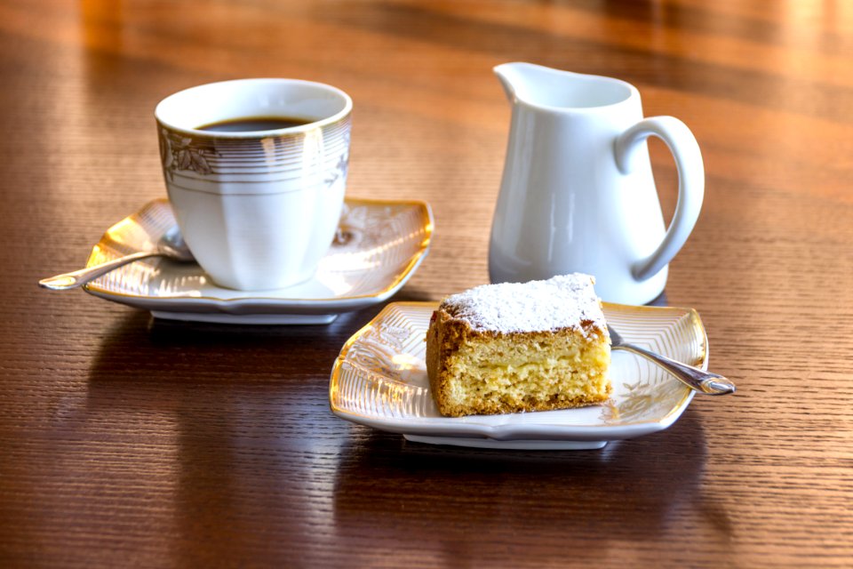 White Ceramic Mug Filled With Black Liquid Beside Baked Bread On Ceramic Saucer photo