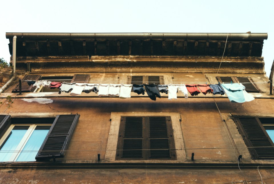 Hanging Clothes And Pants Beside Brown Building