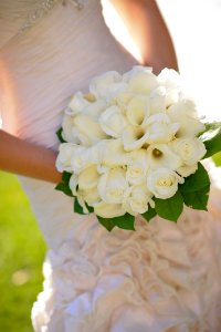 Woman In Wedding Dress Holding White Flower Bouquet photo