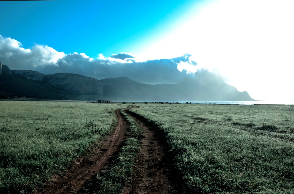 Green Grass Field Beside Brown Mountains Under White Cloudy Sky