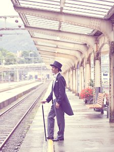 Sepia Effects Photo Of Man In Black Tuxedo Standing On Train Station During Daytime photo