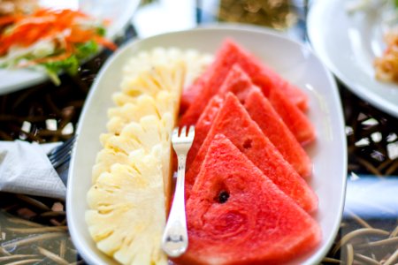 Sliced Watermelon And Pineapple Fruit With Stainless Steel Fork Placed On White Ceramic Rectangular Plate photo