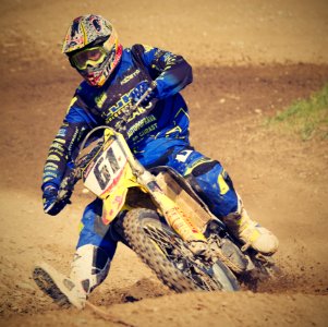 Man In Blue Motorcycle Suit Riding On Yellow Dirt Motorcycle During Daytime photo