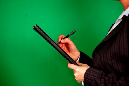 Woman In Gray Pinstripe Blazer Holding Black And Gray Stylus Pen And Black Pad photo