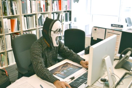 Person Wearing Scream Mask And Black Dress Shirt While Facing Computer Table During Daytime photo