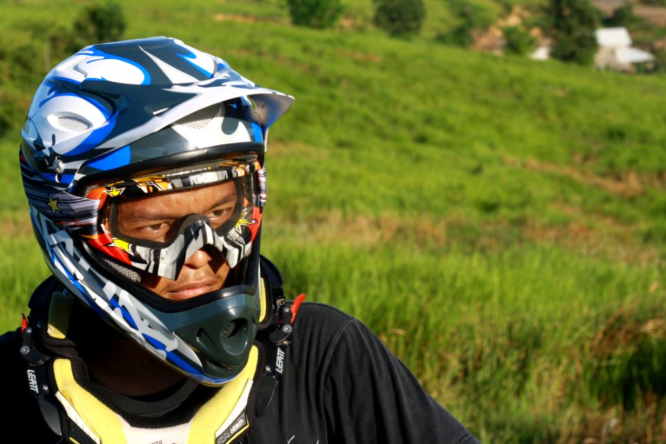 Man Wearing White Blue And Black Motorcycle Helmet During Daytime