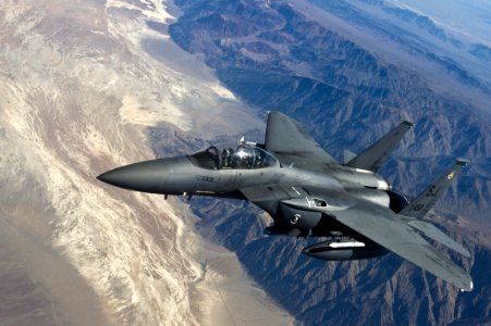 Grey Jet Plane Flying On Top Of White Mountain photo