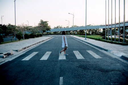 Woman Standing On Gray And White Road Crosswalk photo
