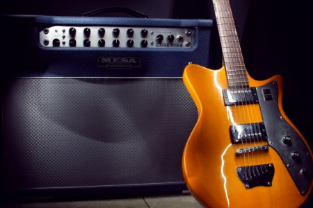 Brown Electric Guitar Beside Black Guitar Amplifier photo