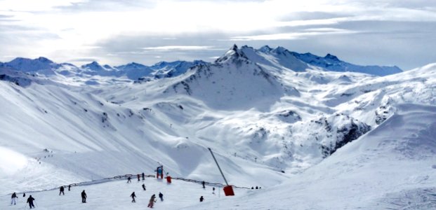 People Lurking Around On Snow Field Near Mountains photo