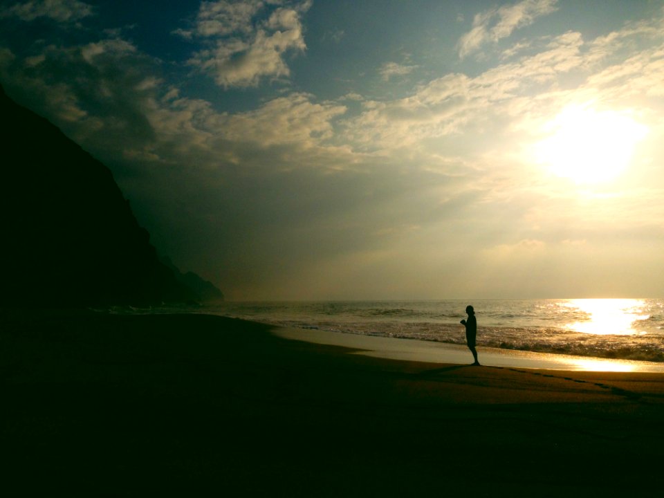 Silhouette Of Person On Beach At Sunset photo