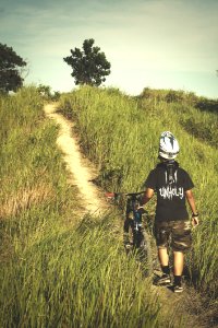 Man In Black Shirt And Brown Shorts Holding Bicycle