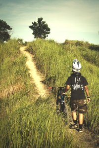 Man In Black Shirt And Brown Shorts Holding Bicycle photo