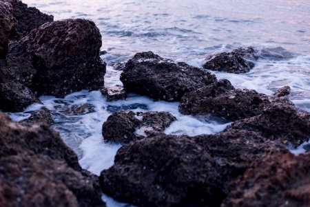 Black And Brown Rocks On Sea During Daylight photo