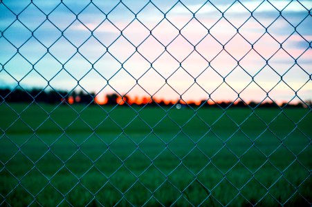Sunset Over Field Through Fence photo