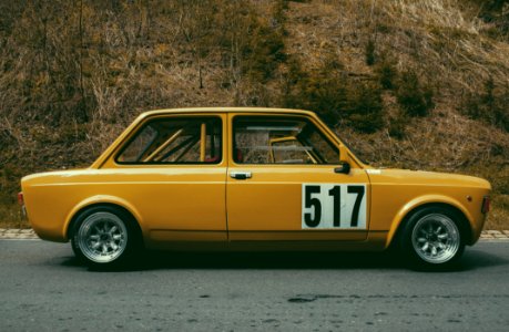 Yellow Sedan Beside Brown Leaf Plant During Daytime photo