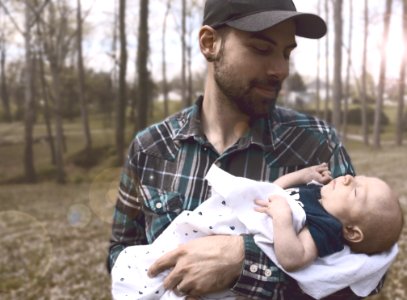 Man Holding Baby During Daytime photo