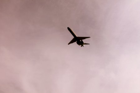 Airplane Flying In Mid Air Under Gray Clouds
