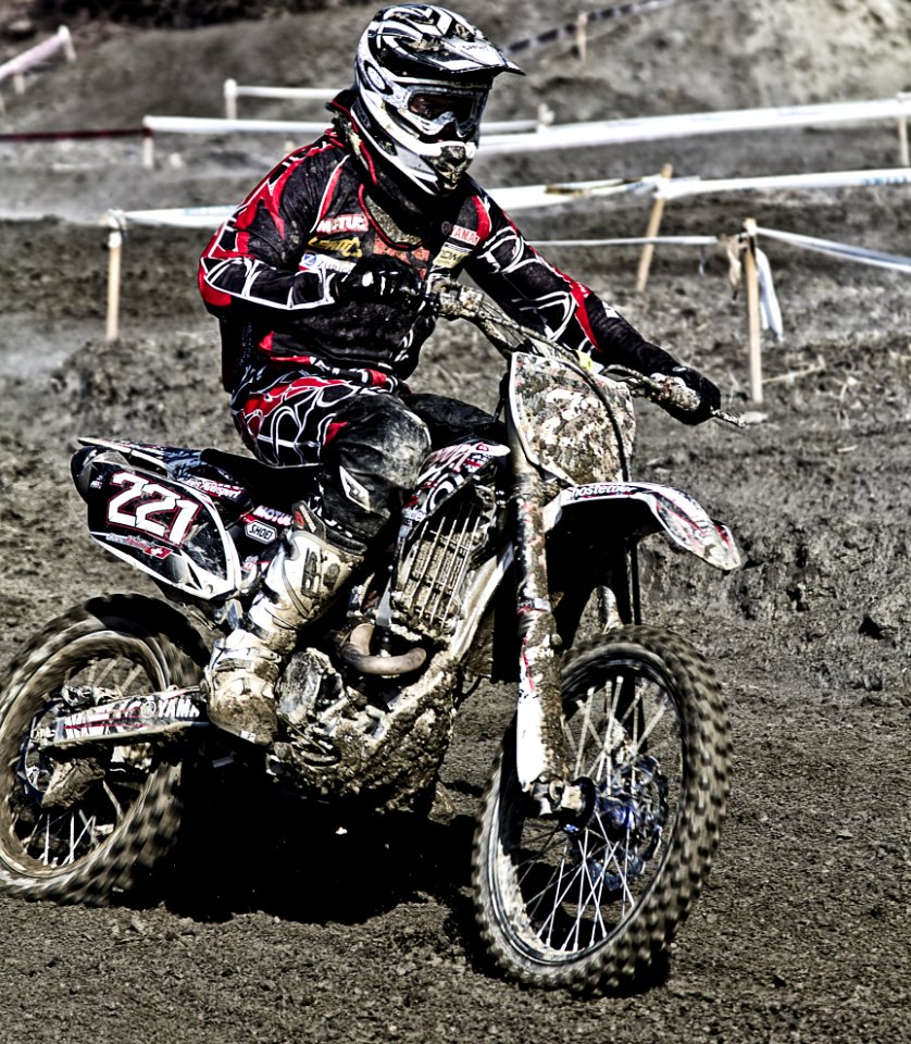 Person Riding On Motorcycle On Motocross Race Track Wearing White And Black Oakley Full Face Helmet During Daytime