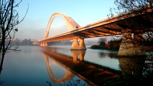 Grey Concrete Bridge Above Water Under Blue Sky photo