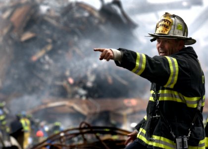 Fire Fighter Wearing Black And Yellow Uniform Pointing For Something
