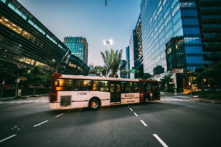 White Bus On Road Near In High Rise Building During Daytime