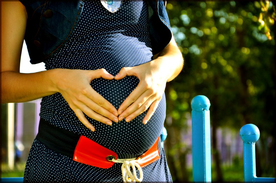 Pregnant Woman Holding Her Tummy During Daytime