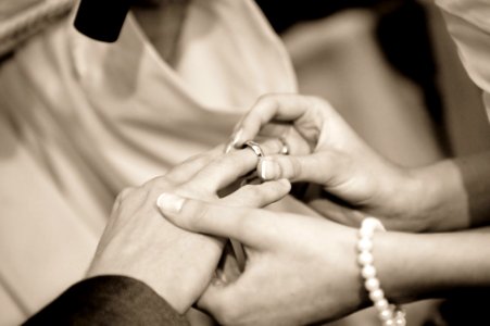 Person Putting Ring On Another Person In Grayscale Photography photo