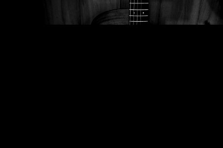 Greyscale Photo Of Acoustic Guitar On Wooden Fence
