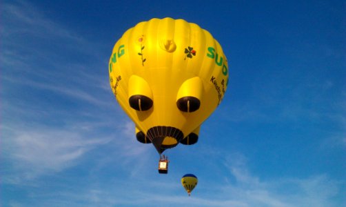 Yellow And Black Hot Air Balloons On Mid Air Under White Clouds Blue Sky During Daytime