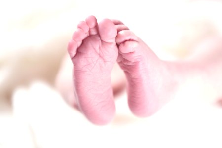 Babys Foot On White Textile