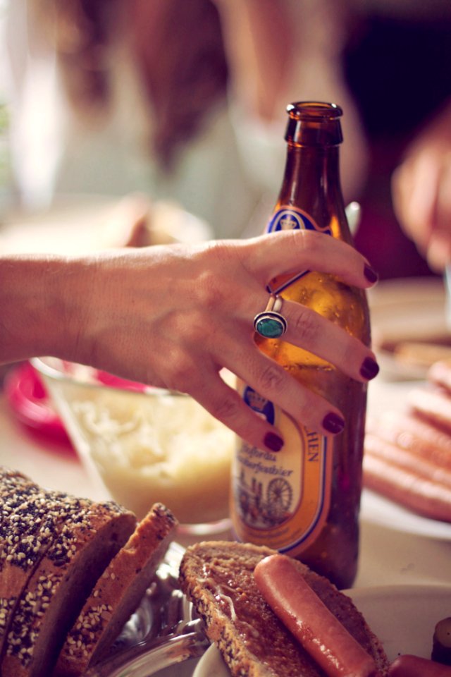 Person Holding Brown Labeled Bottle