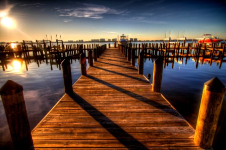 Brown Wooden Dock On Blue Water Under White Clouds And Blue Sky During Daytime photo